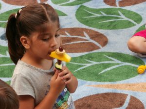 Child eating fruit skewer