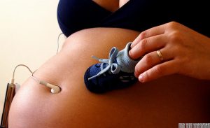 Pregnant woman and baby shoes
