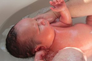 newborn baby being bathed